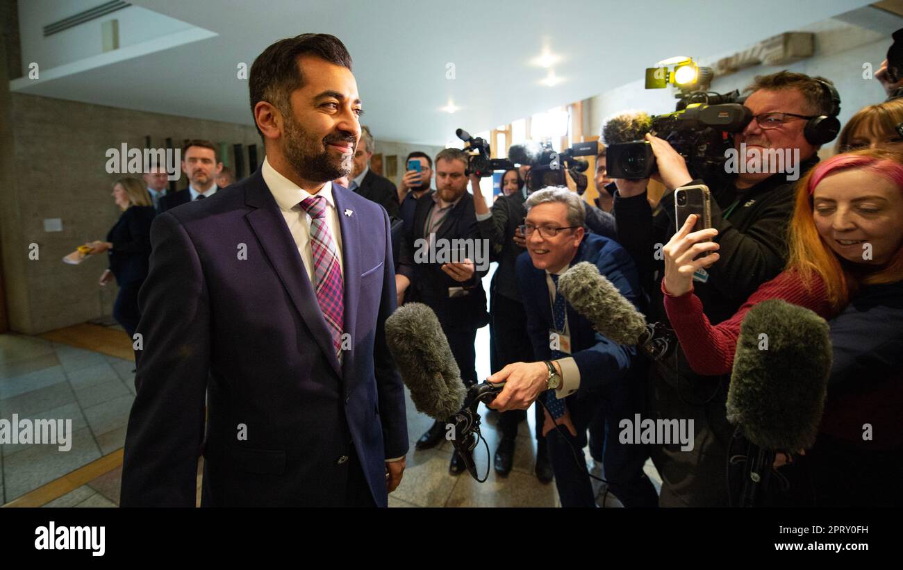 Edinburgh, Scotland, UK. 27th Apr, 2023. PICTURED: Humza Yousaf MSP, First Minister of Scotland and Leader of the Scottish National Party (SNP), seen being questioned by awaiting media and journalists immediately after FMQs session has finished. Weekly session of First Ministers Questions as Humza Yousaf MSP, First Minister of Scotland takes questions in the chamber. Scenes also inside the corridor before and after FMQs. Credit: Colin Fisher/Alamy Live News Stock Photo