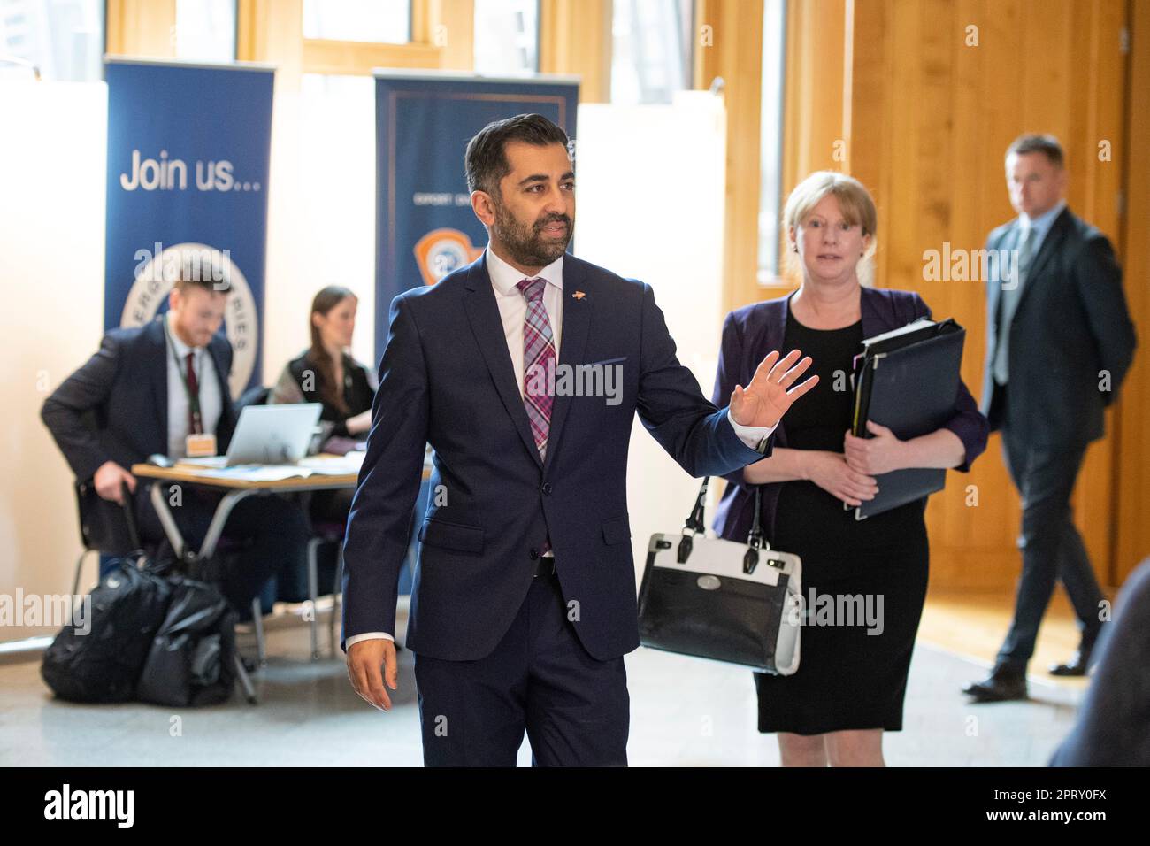 Edinburgh, Scotland, UK. 27th Apr, 2023. PICTURED: Humza Yousaf MSP, First Minister of Scotland and Leader of the Scottish National Party (SNP), seen being questioned by awaiting media and journalists immediately after FMQs session has finished. Weekly session of First Ministers Questions as Humza Yousaf MSP, First Minister of Scotland takes questions in the chamber. Scenes also inside the corridor before and after FMQs. Credit: Colin Fisher/Alamy Live News Stock Photo