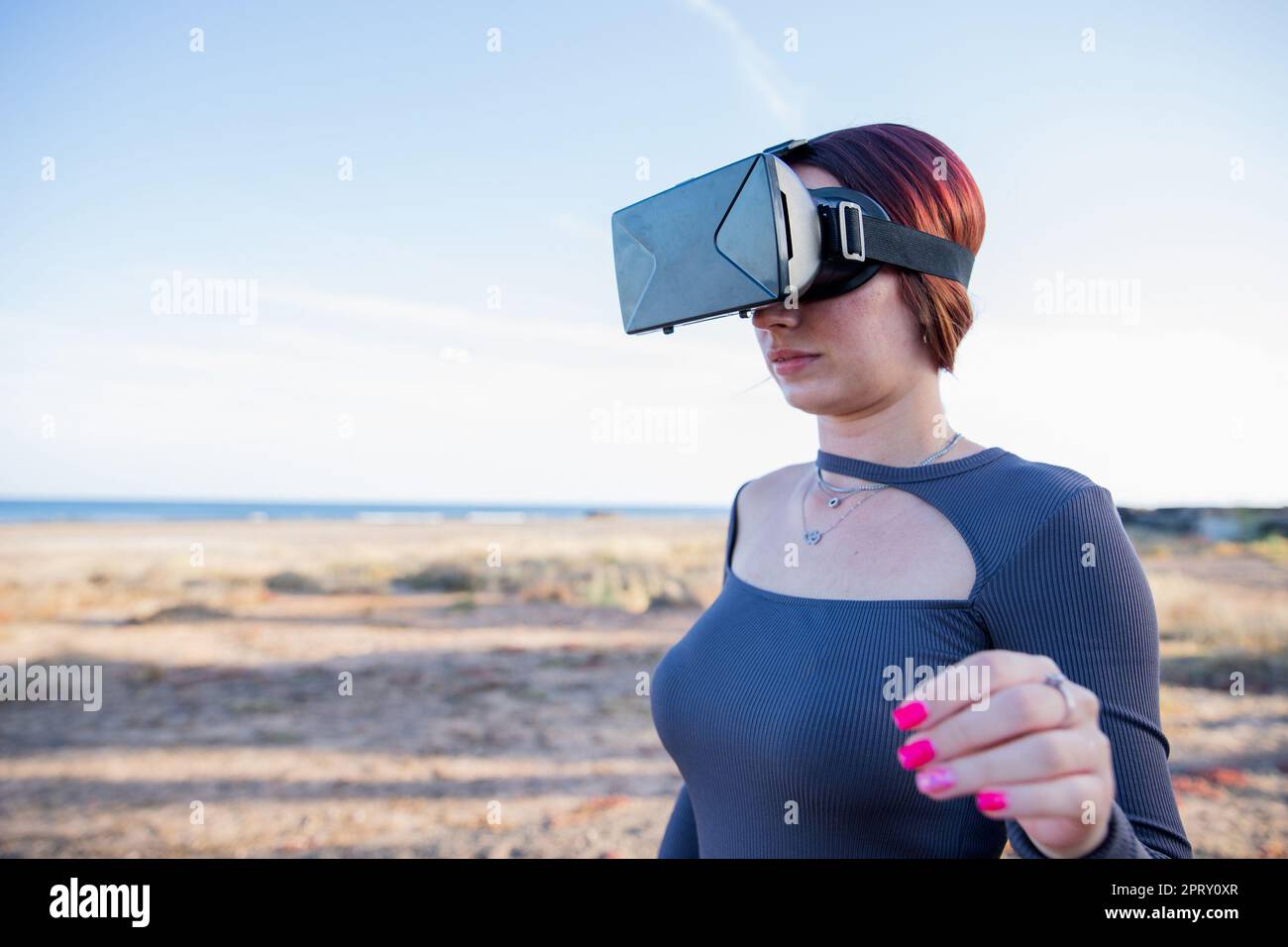 A tourist uses virtual reality headsets while at the beach, technology