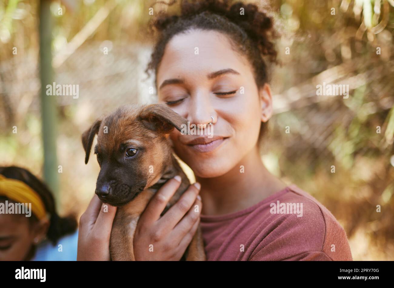 Love, dog and animal shelter with a black woman hugging a foster pet while at a shelter to adopt a rescue animal. Volunteer, charity and adoption with Stock Photo