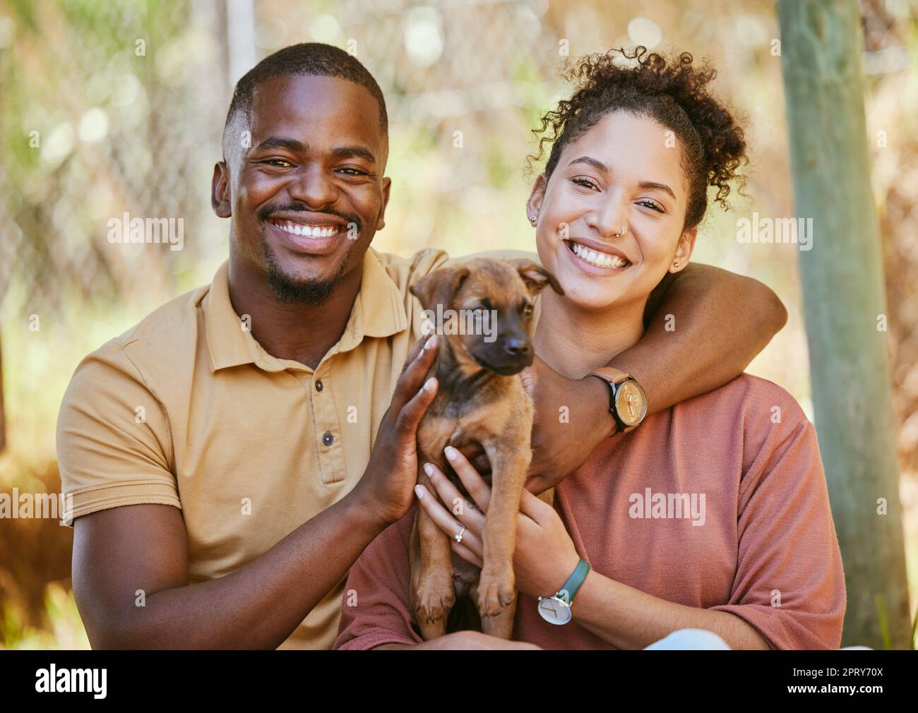 Love, portrait and black couple with dog at animal shelter for adoption at kennel. Support, care or happy interracial couple, man and woman bonding wi Stock Photo