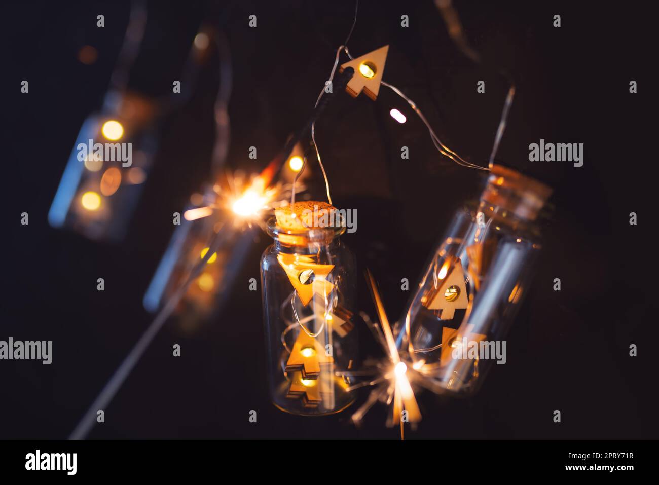 Garland of christmas lights on dark night sky. Illuminated string of