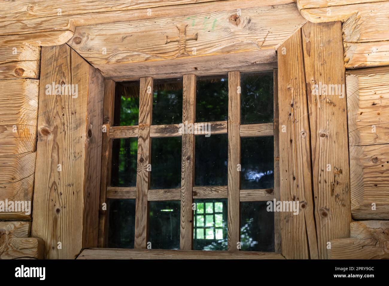 Window in a wooden house. wooden house with window frame. Old wooden house in the village, Wood board background, texture. Window with glass and frame Stock Photo