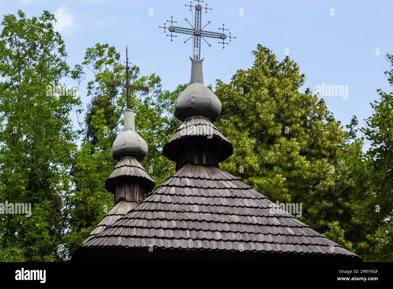 old wooden church against the blue sky in Ukraine, wooden roof with a