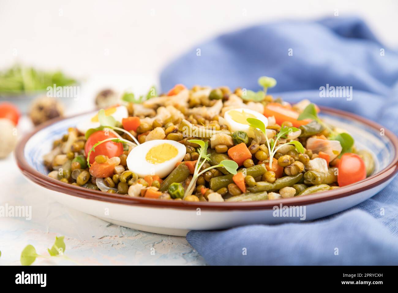 Mung bean porridge with quail eggs, tomatoes and microgreen sprouts on