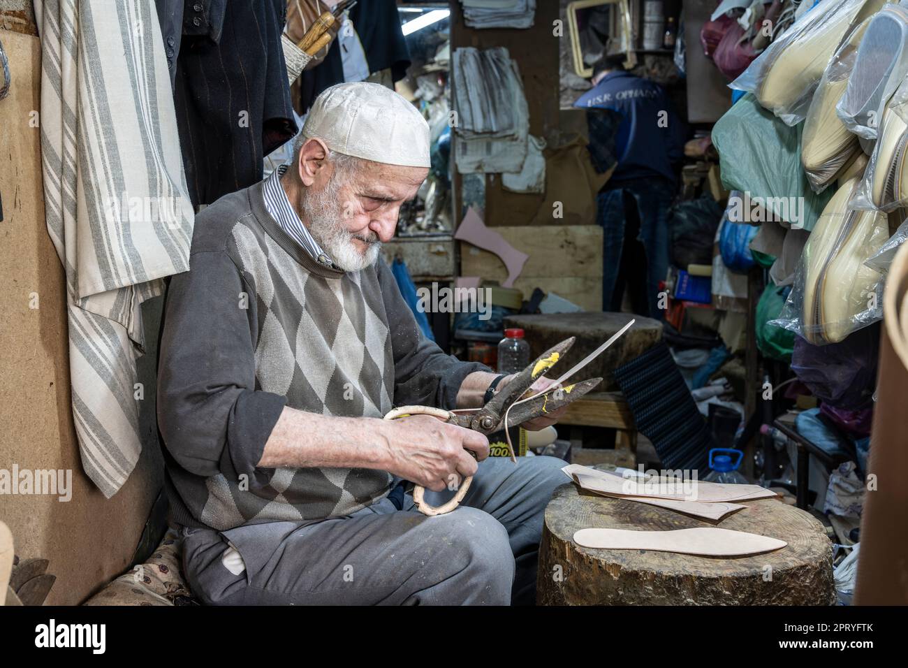 Shoemaker craftsman cutting leather insoles for making slippers. Stock Photo