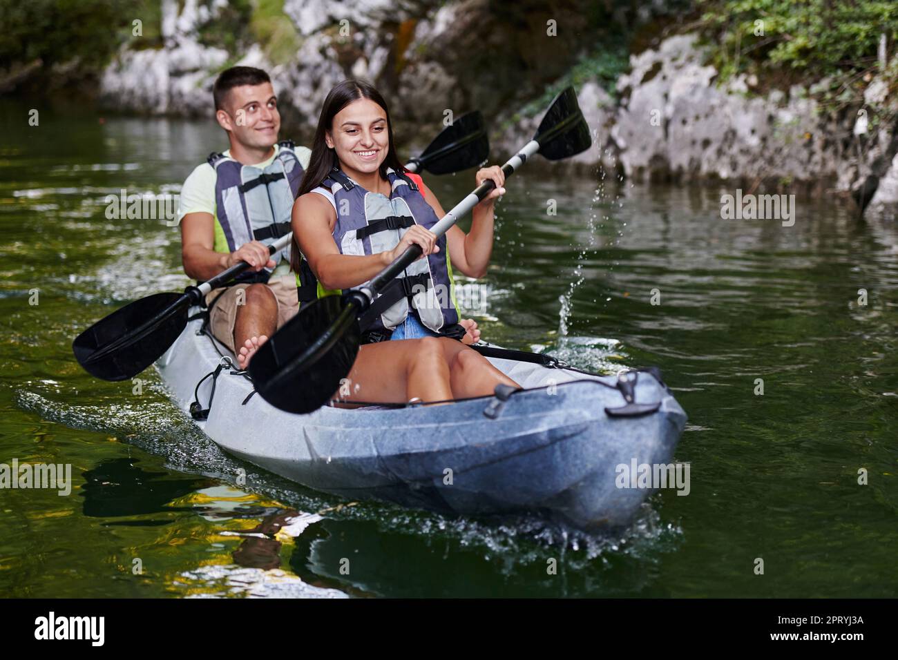 A young couple enjoying an idyllic kayak ride in the middle of a ...