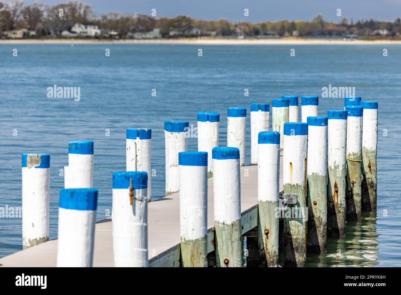 a shelter island dock with white pilings and blue caps at cresent beach Stock Photo