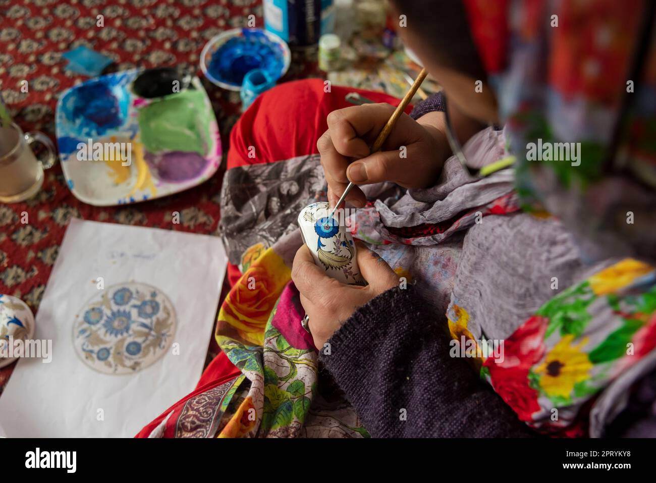 Srinagar, India, 27/04/2023, A woman artisan is seen designing a Paper