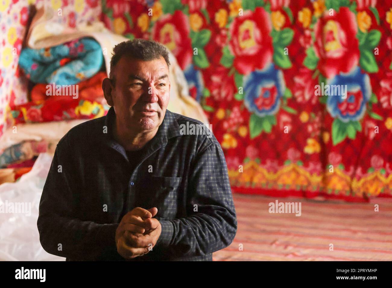 (230427) -- YULI, April 27, 2023 (Xinhua) -- Arkin Reyim talks with his family members in Yuli County, northwest China's Xinjiang Uygur Autonomous Region, April 1, 2023.  Arkin Reyim is a 51-year-old cotton farmer with more than 300 mu (20 hectares) of cotton fields in the Bax Mali Village of Yuli County in Xinjiang.     Arkin's courage and unique vision has prompted him to start growing cotton in 2004 when he got married with his wife Hasiyat Kasim. Since then, Arkin has devoted himself into the cultivation of cotton for over 10 years, thus making him an experienced cotton grower in the count Stock Photo