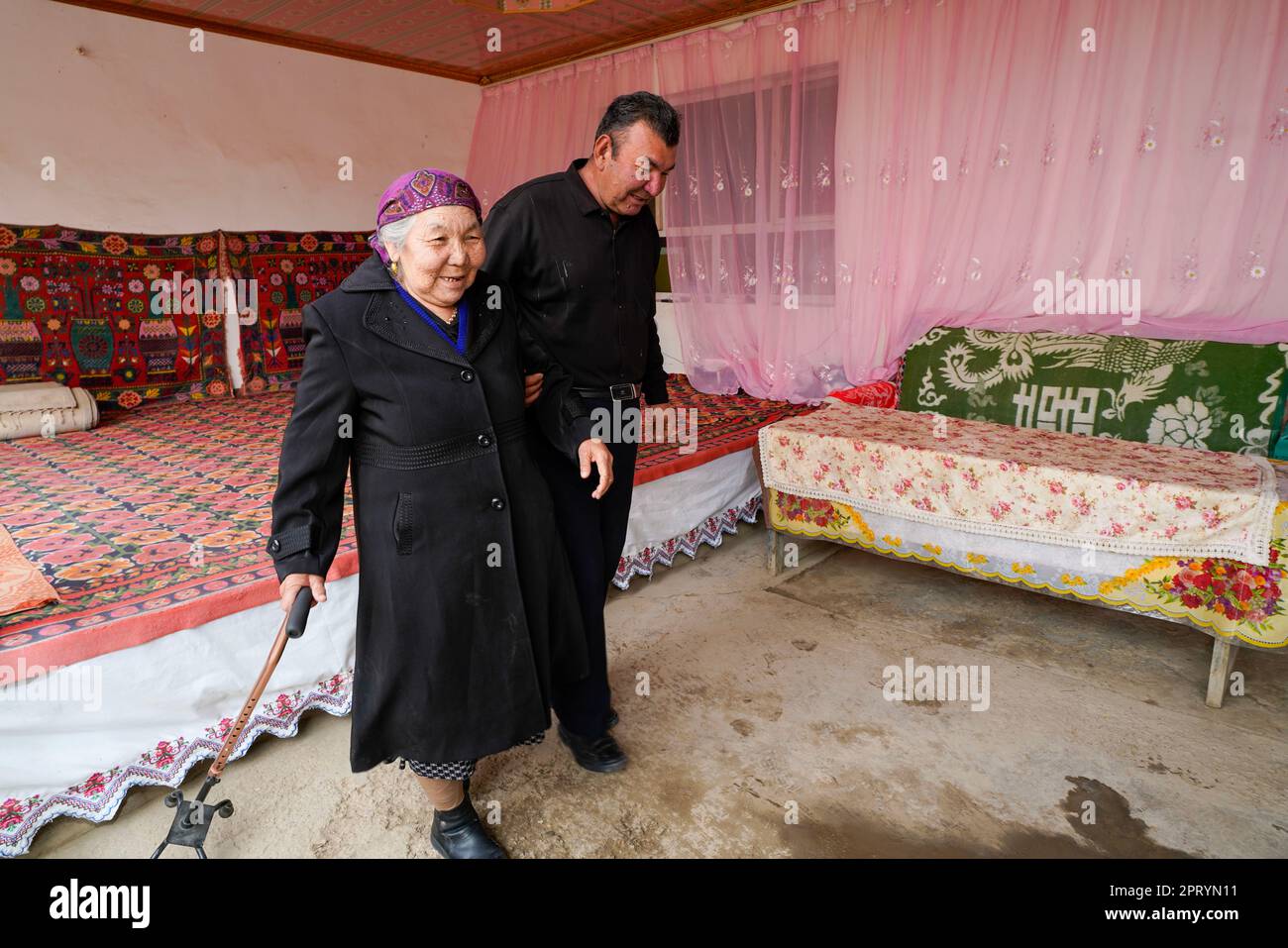 (230427) -- YULI, April 27, 2023 (Xinhua) -- Arkin Reyim takes his mother to go for a meal in the Bax Mali Village of Yuli County, northwest China's Xinjiang Uygur Autonomous Region, April 22, 2023.  Arkin Reyim is a 51-year-old cotton farmer with more than 300 mu (20 hectares) of cotton fields in the Bax Mali Village of Yuli County in Xinjiang.     Arkin's courage and unique vision has prompted him to start growing cotton in 2004 when he got married with his wife Hasiyat Kasim. Since then, Arkin has devoted himself into the cultivation of cotton for over 10 years, thus making him an experienc Stock Photo