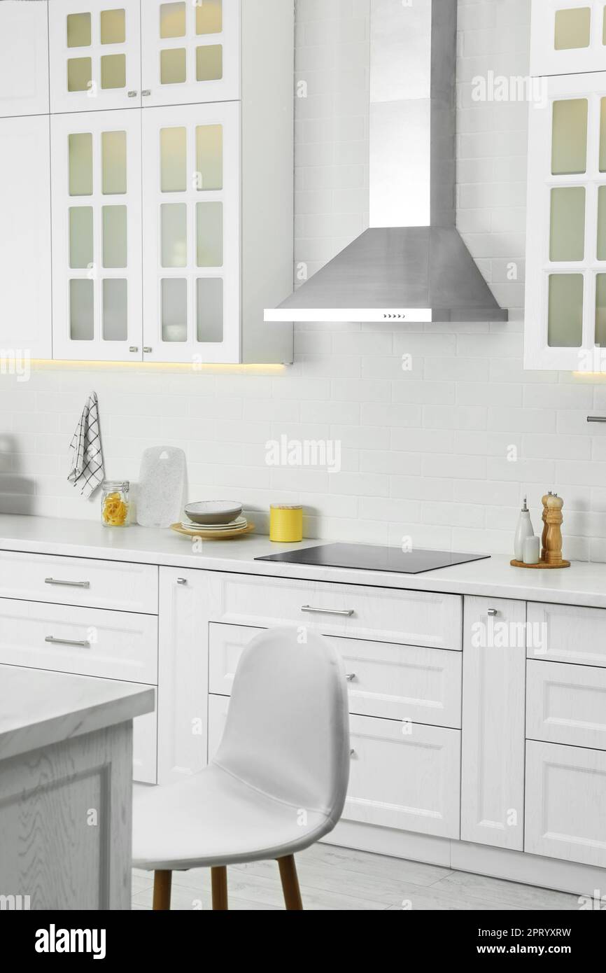 Elegant kitchen interior with modern range hood over cooktop and