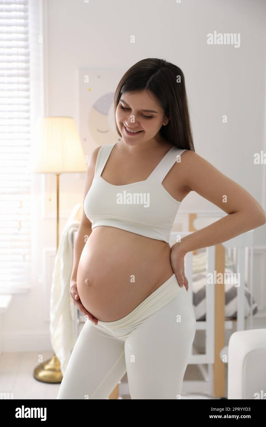 Happy pregnant woman at home. Choosing baby name Stock Photo