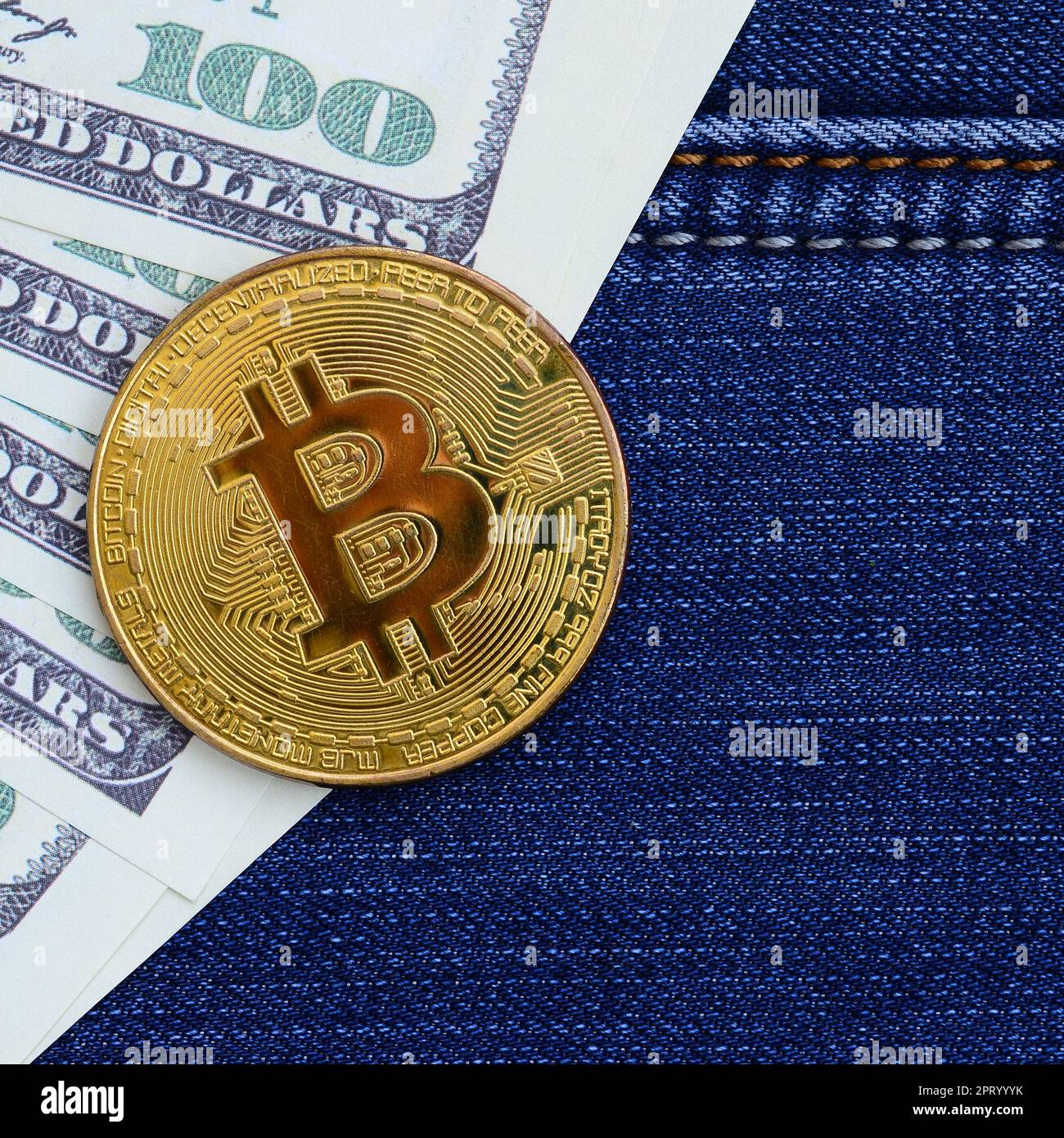 Golden Bitcoin and dollar bills lies on a blue jeans fabric. New virtual  money. New crypto currency in the form of the coins Stock Photo - Alamy