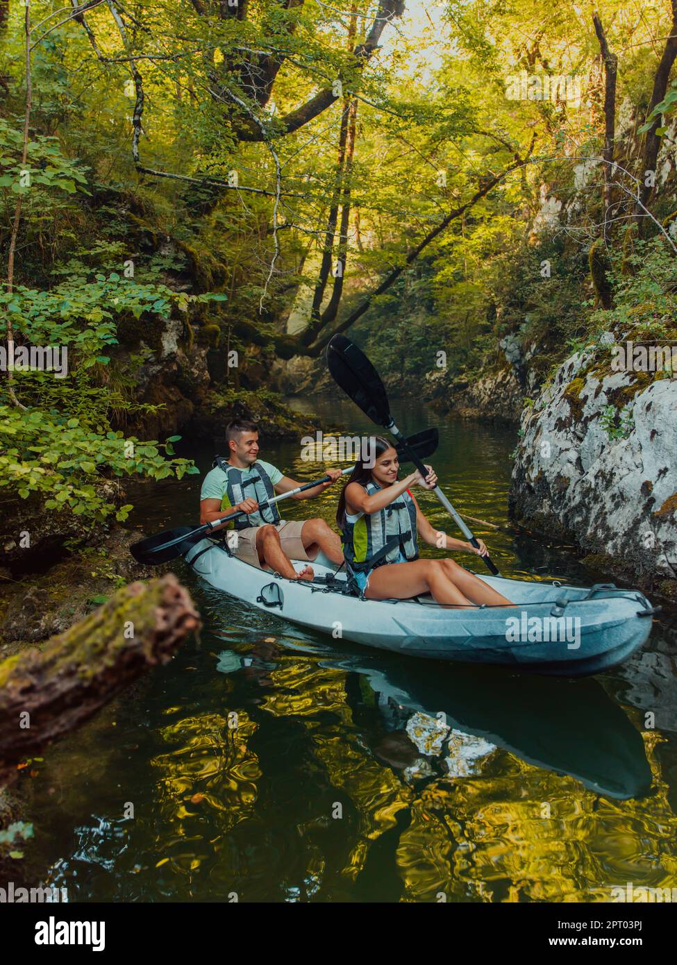 A young couple enjoying an idyllic kayak ride in the middle of a ...