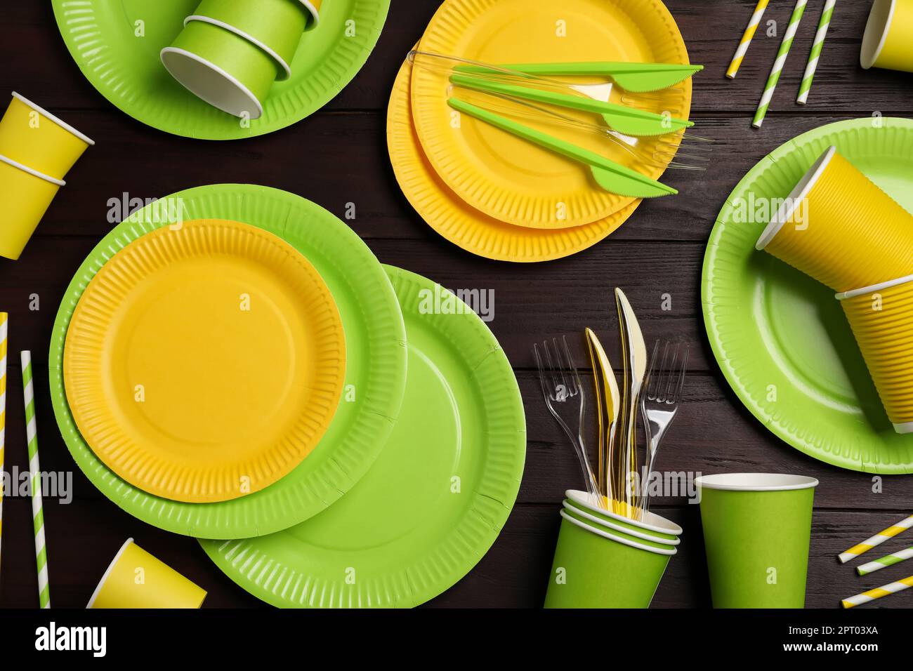 Flat lay composition with disposable tableware on wooden background ...