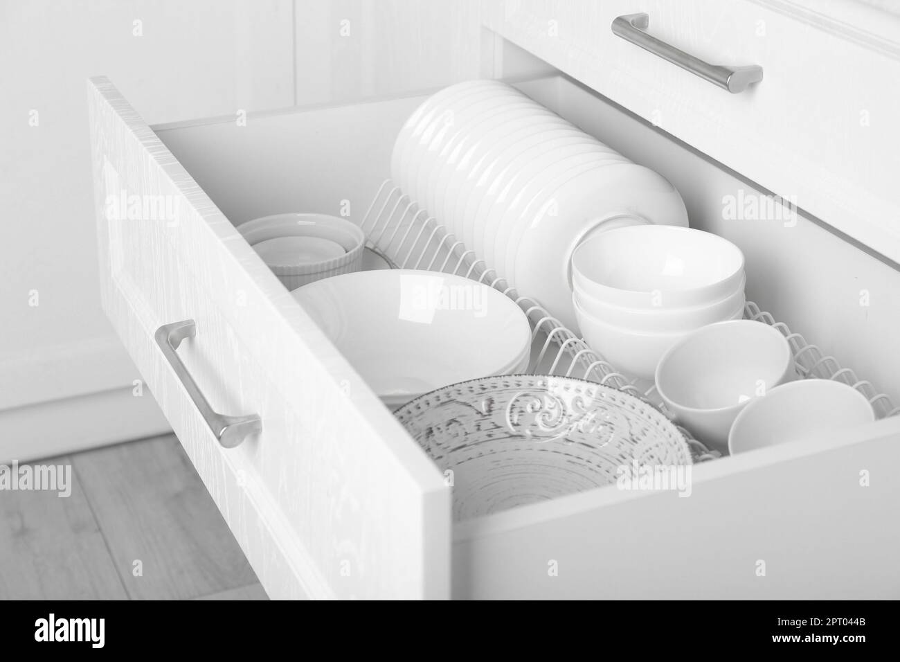 Open drawer with different plates and bowls in kitchen Stock Photo Alamy