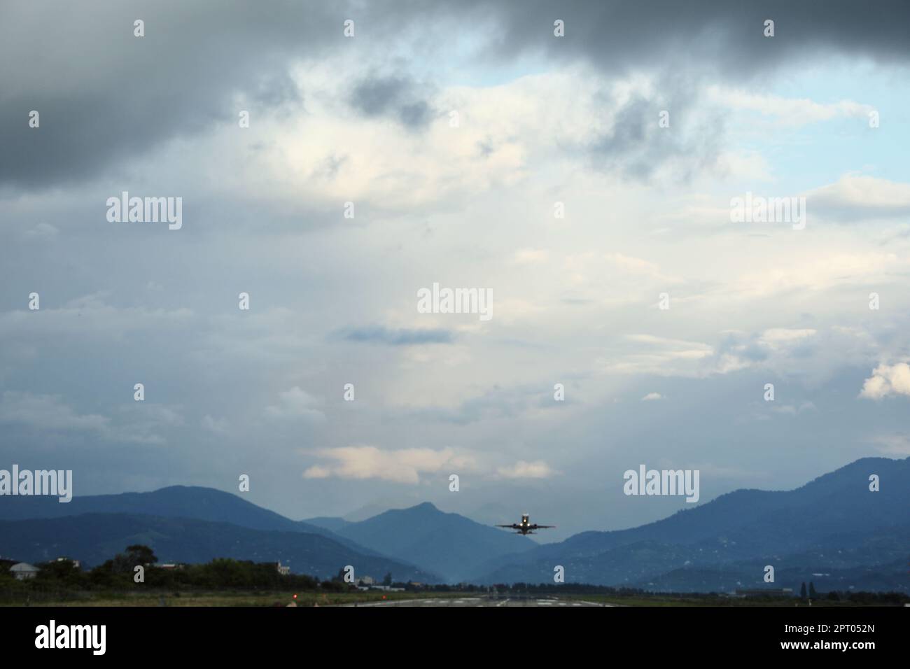 Modern white airplane and takeoff runway in evening Stock Photo