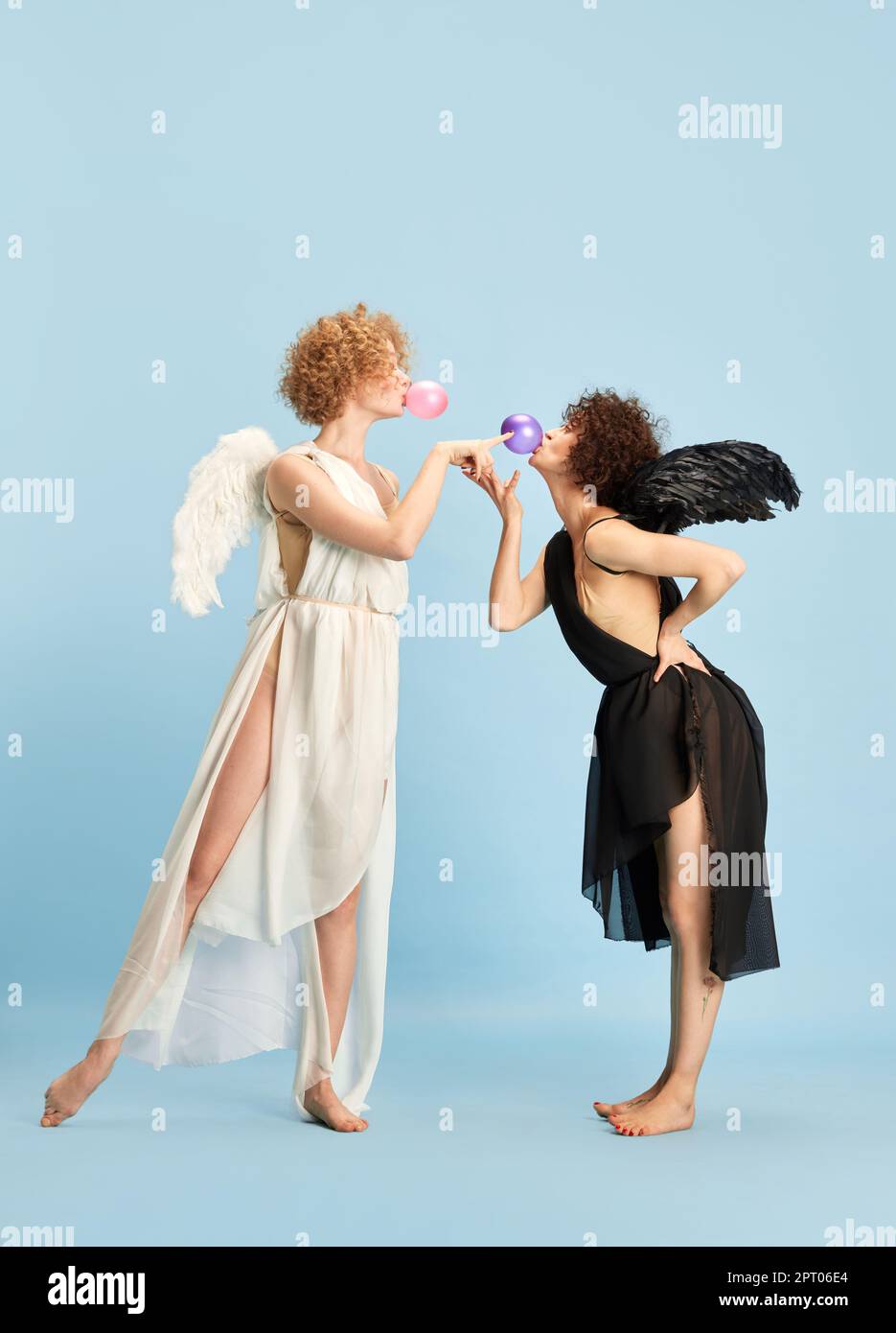 Tandem of evil and kindness. Portrait of two beautiful young women in ...