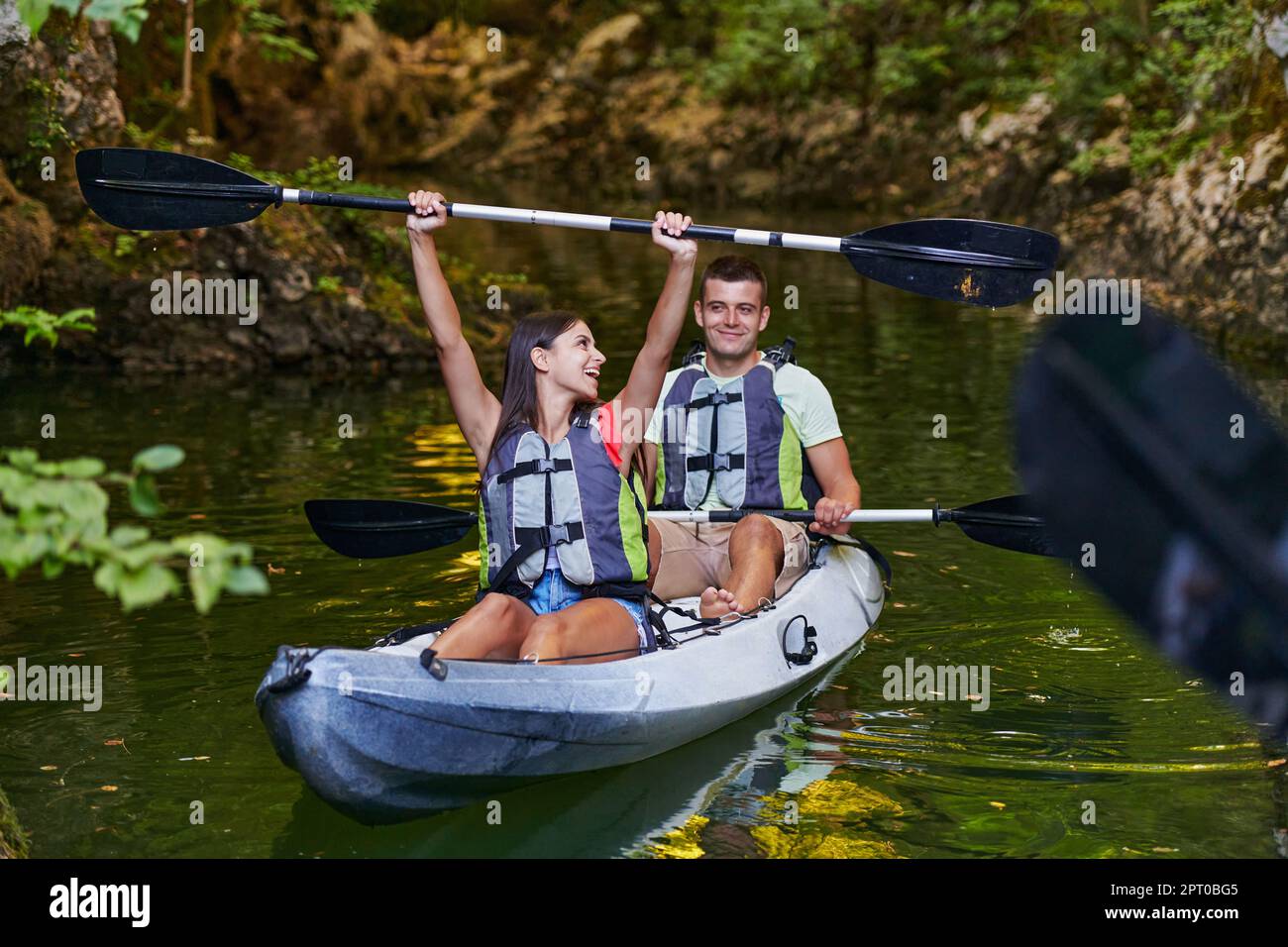 A young couple enjoying an idyllic kayak ride in the middle of a ...