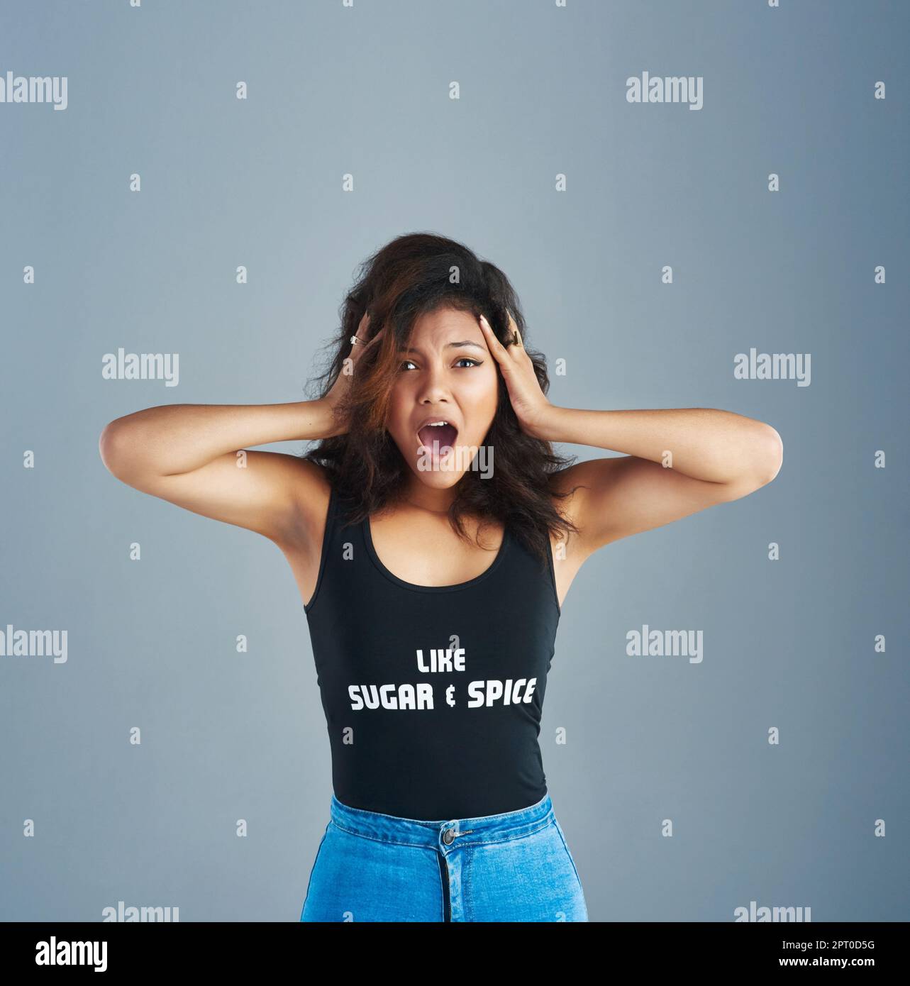 Im freaking out. Portrait of an attractive young woman posing against a gray background Stock Photo