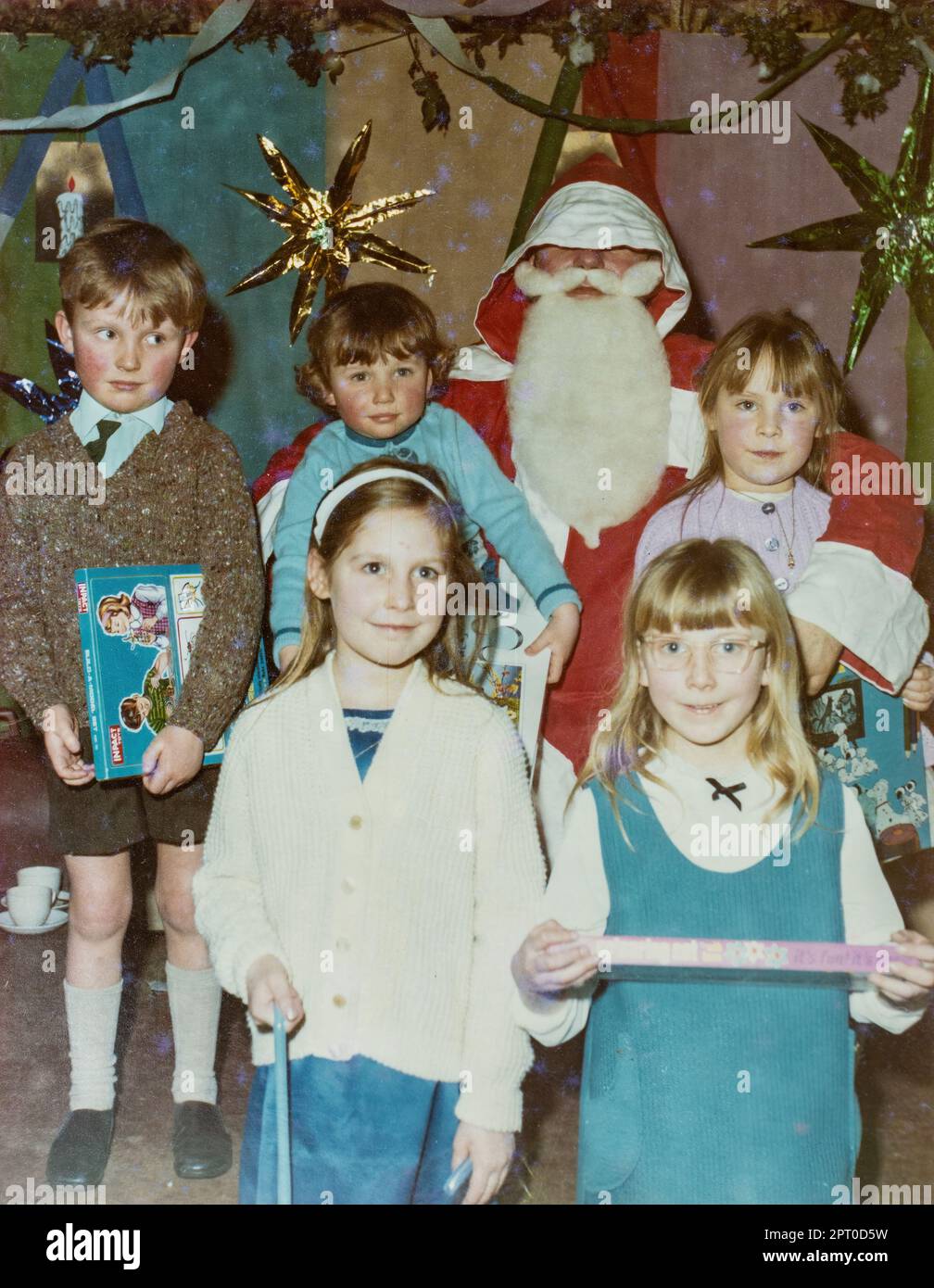 Children with Father Christmas Santa Claus holding their presents, archival photo from the late 1960s, England, UK Stock Photo