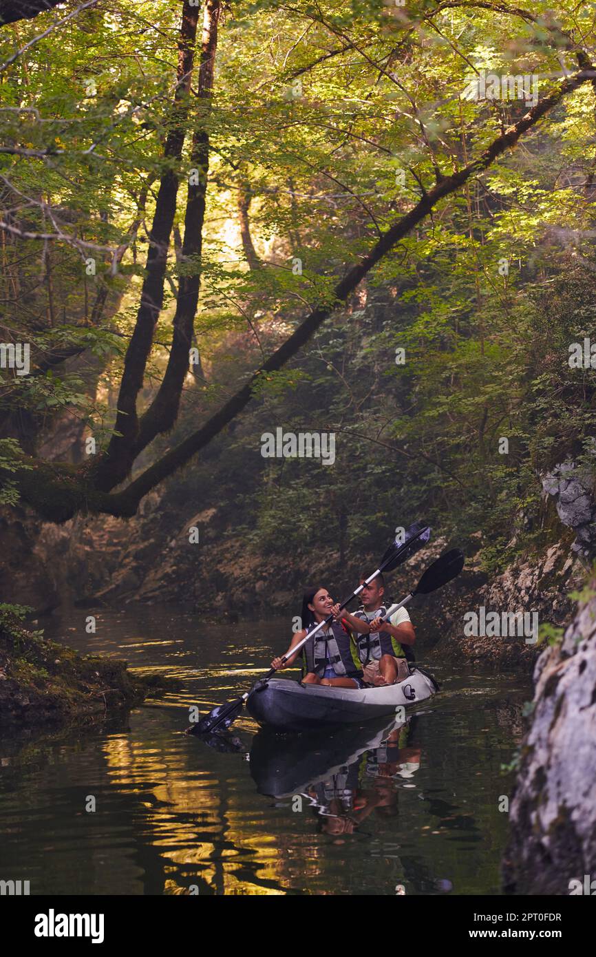 A young couple enjoying an idyllic kayak ride in the middle of a ...