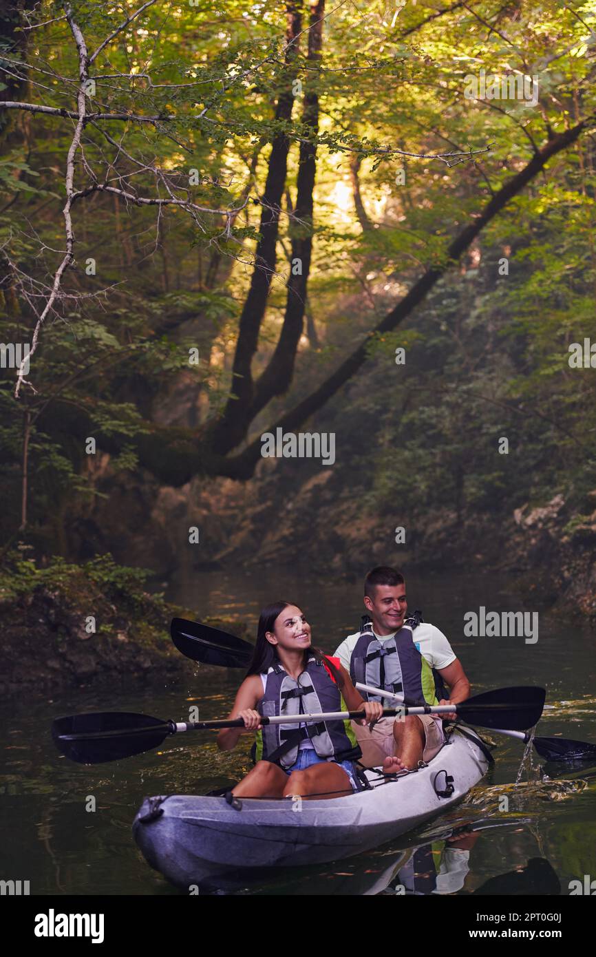 A young couple enjoying an idyllic kayak ride in the middle of a ...