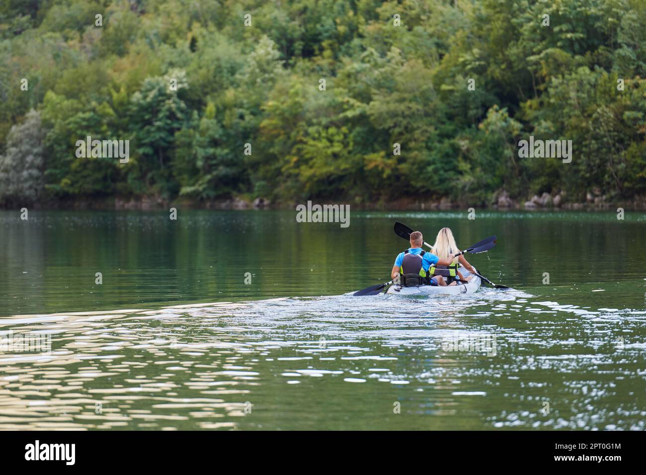 A young couple enjoying an idyllic kayak ride in the middle of a ...