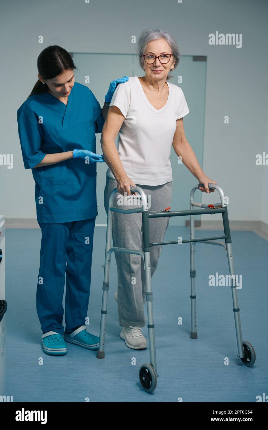 Elderly patient walks with a walker along the hospital corridor Stock ...