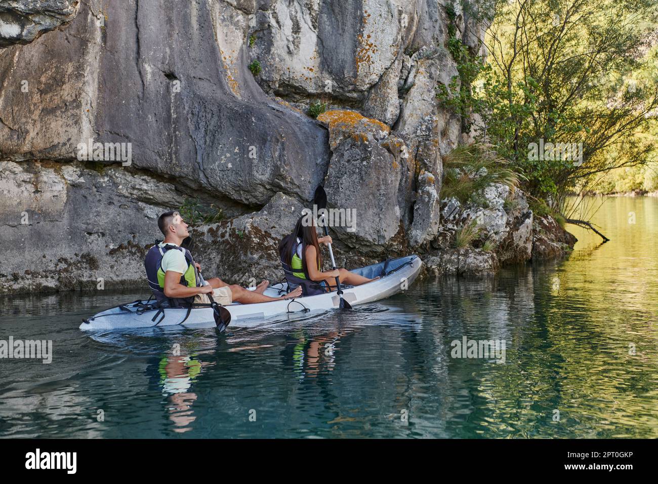 A young couple enjoying an idyllic kayak ride in the middle of a ...