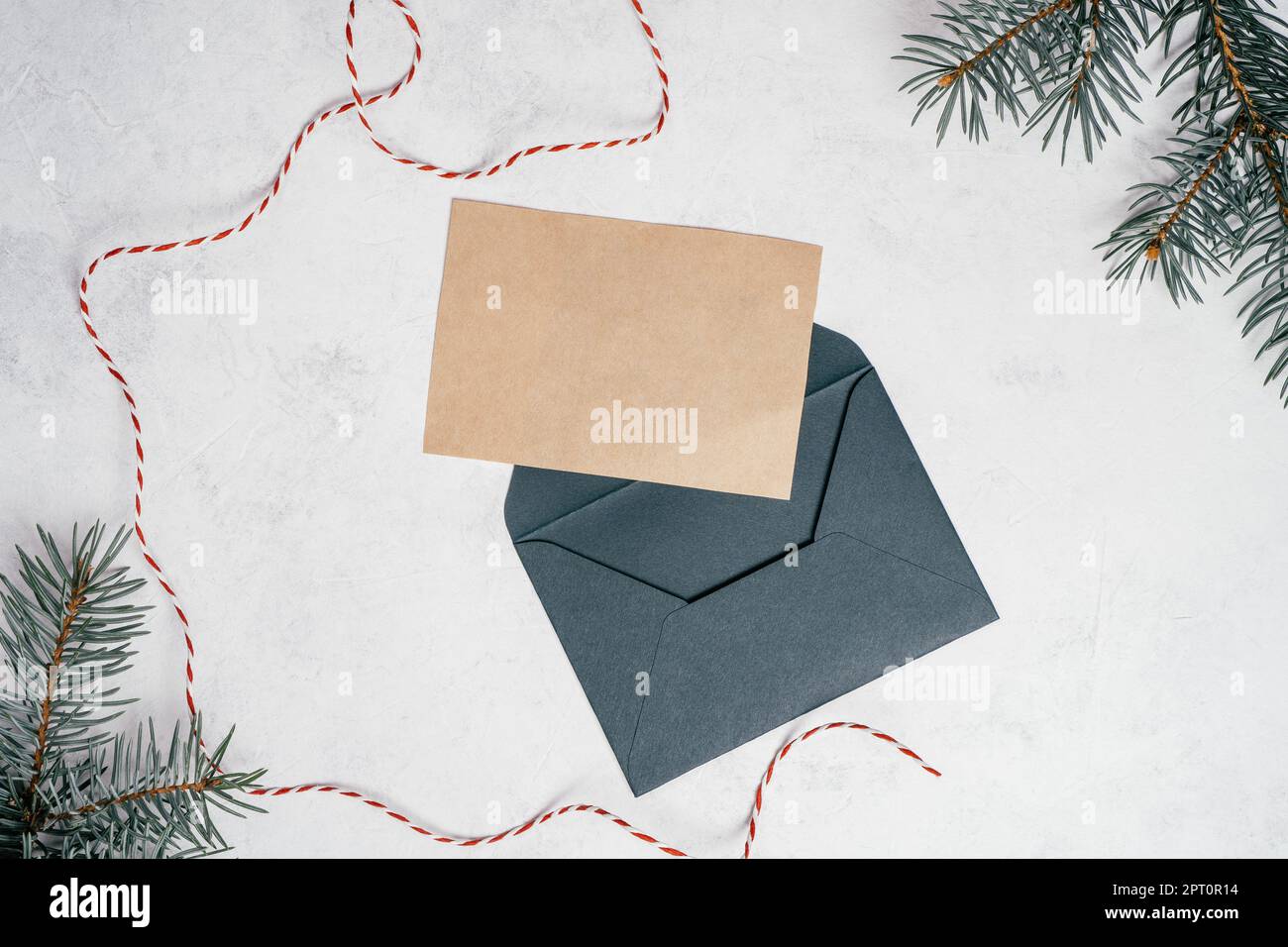 Green open envelope on white concrete background with blank kraft paper