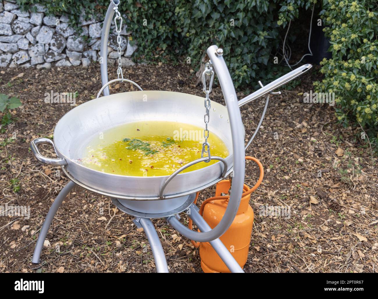 https://c8.alamy.com/comp/2PT0R67/chopped-garlic-and-onion-frying-with-olive-oil-in-a-big-frying-pan-outdoor-close-up-traditional-italian-and-apulian-cousine-cooking-for-huge-family-2PT0R67.jpg