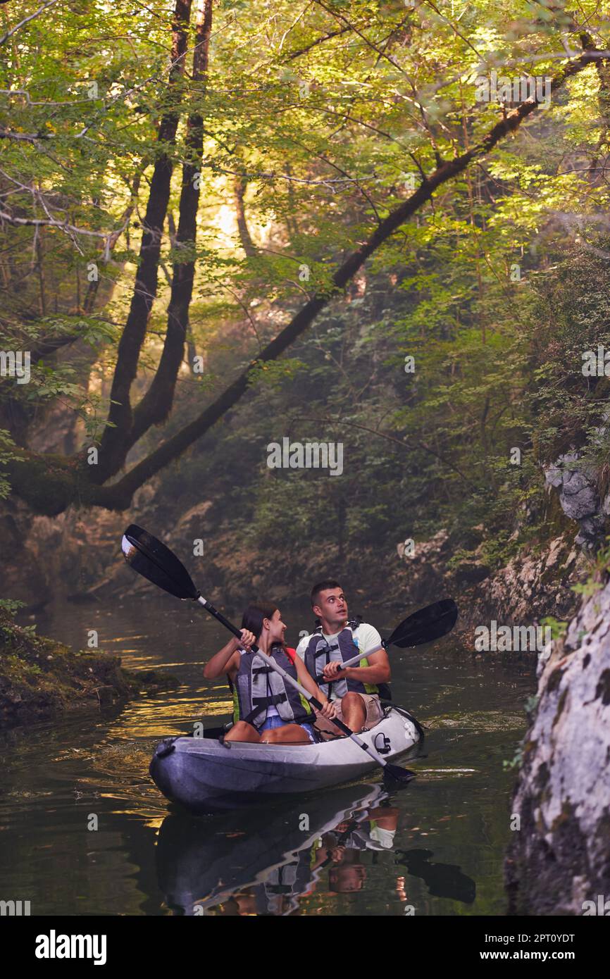 A young couple enjoying an idyllic kayak ride in the middle of a ...