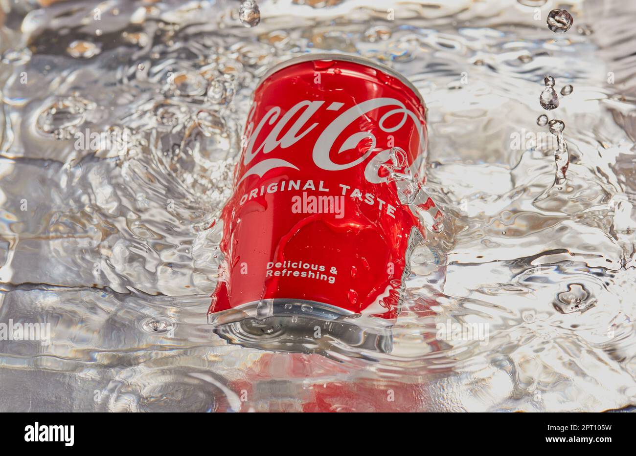 Can of coca cola with water being splashed over it. Stock Photo