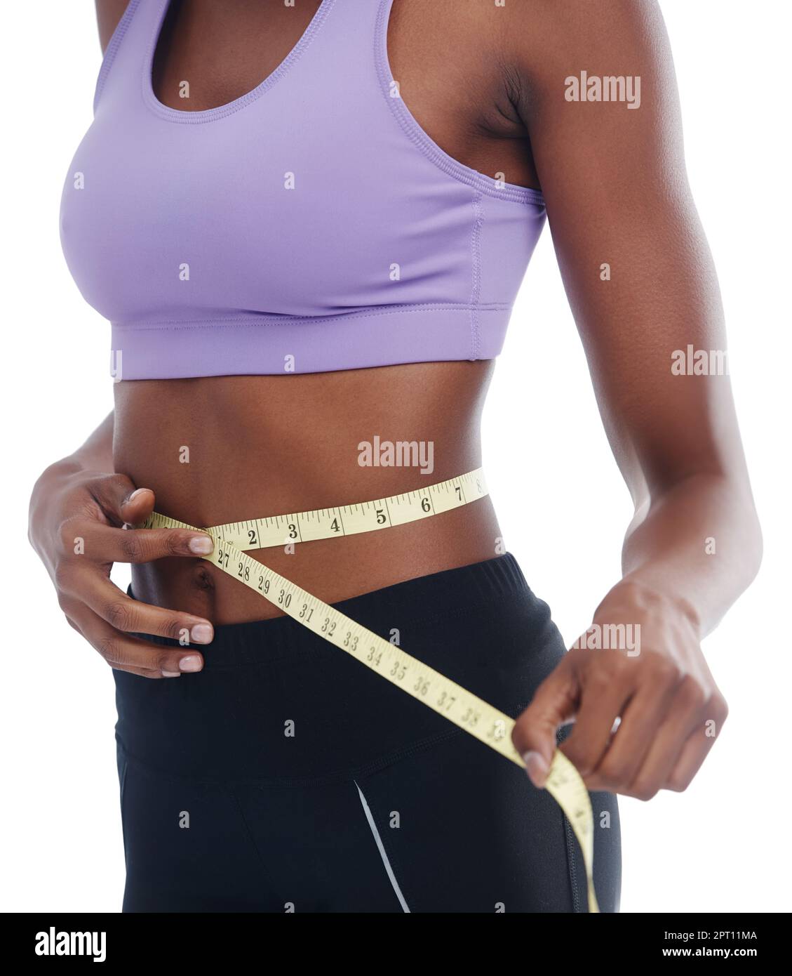 Cropped view of young woman measuring her waist with tape measure
