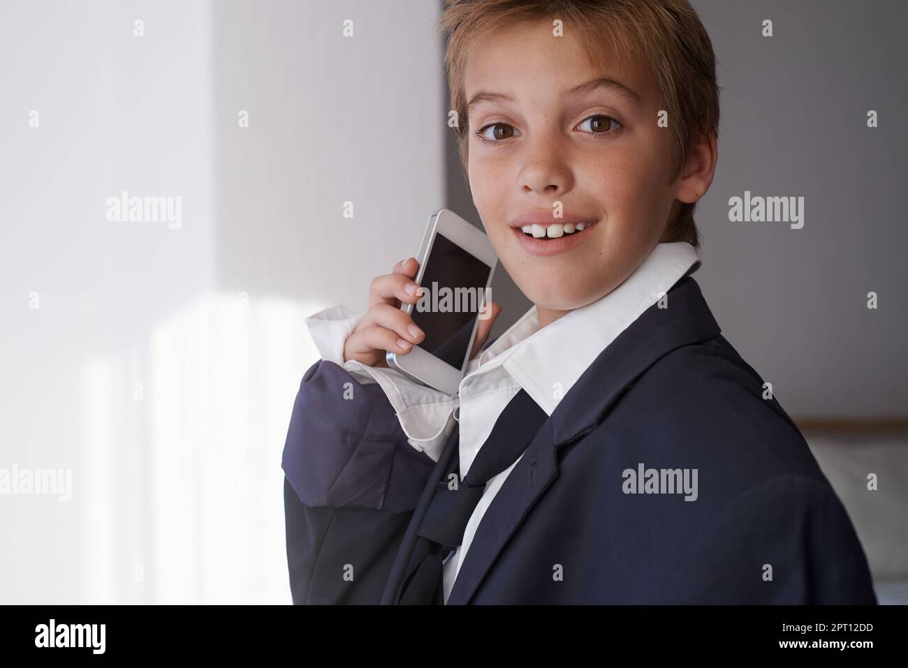 Foto de Serious child wearing suit that is too big for him do