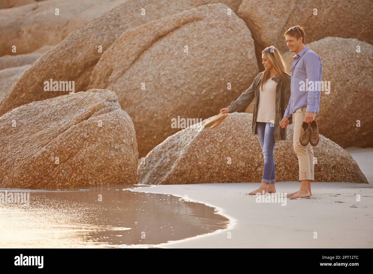 Lets dip our feet in the water. a happy young couple enjoying a