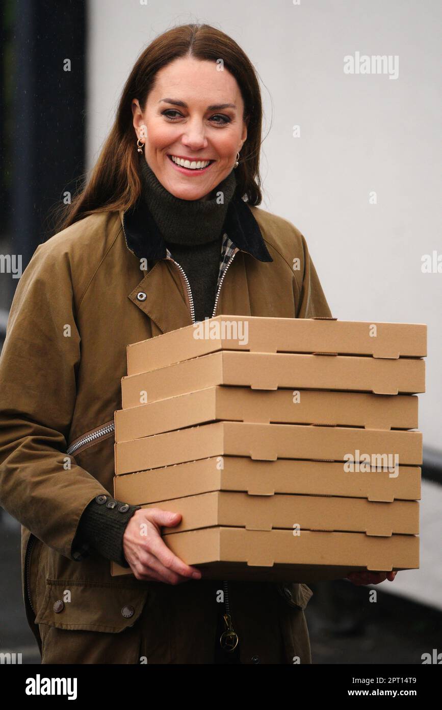 The Princess of Wales holds pizzas to say thank you to the mountain rescue team as she arrives for a visit to Dowlais Rugby Club near Merthyr Tydfil in Wales to meet with mountain rescue volunteers and supporters. The volunteer-run organisation, which covers the central area of the Bannau Brycheiniog National Park including Pen y Fan, is celebrating its 60th birthday. Picture date: Thursday April 27, 2023. Stock Photo