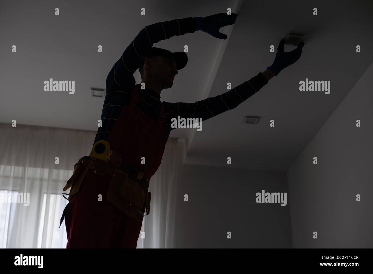 Construction worker ceiling work. working on repairs Stock Photo - Alamy