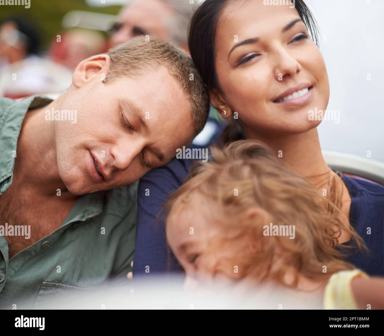 Wherever we are together, that is home. a happy young family falling asleep on their bus trip