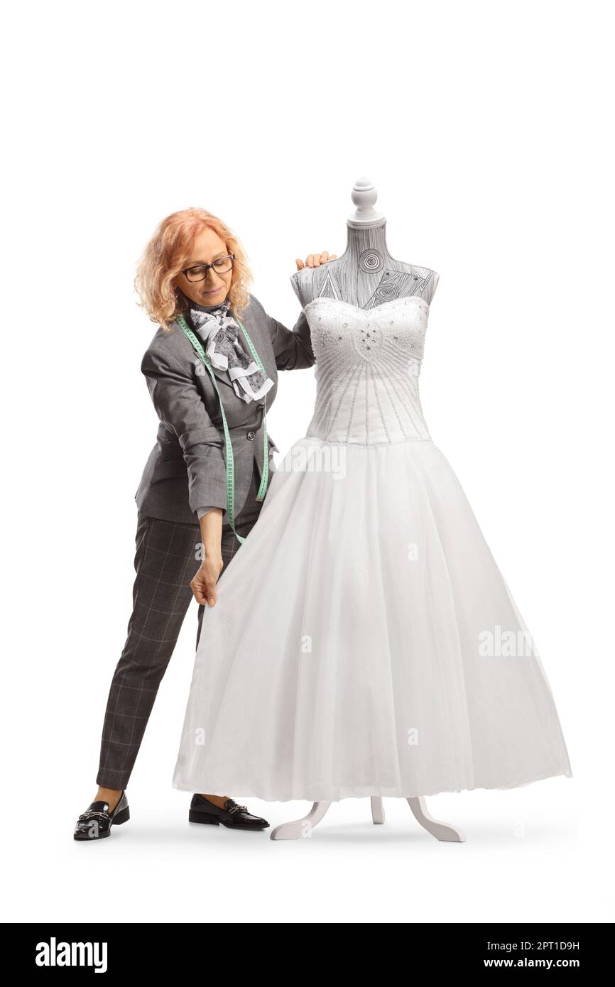 Woman measuring a bridal gown on a mannequin doll isolated on white background Stock Photo