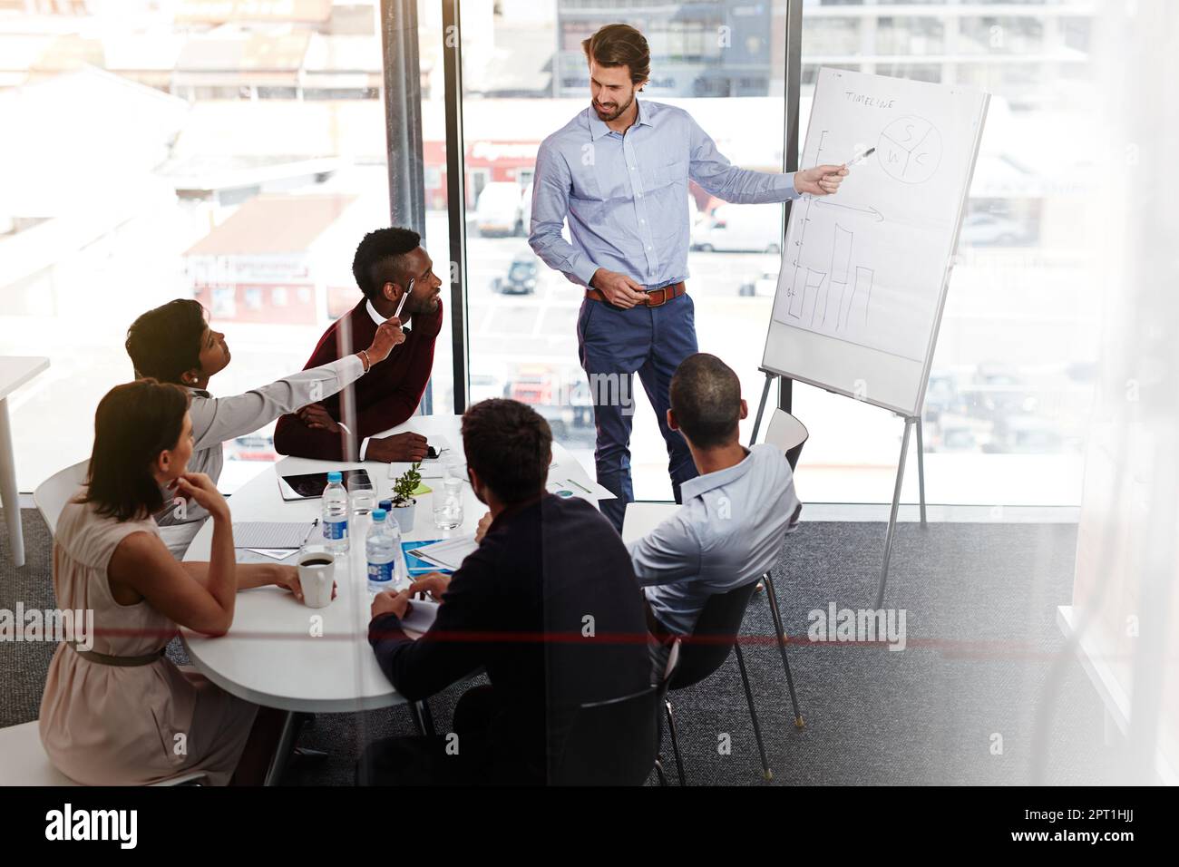 Getting some input form his team. a businessman giving a whiteboard ...