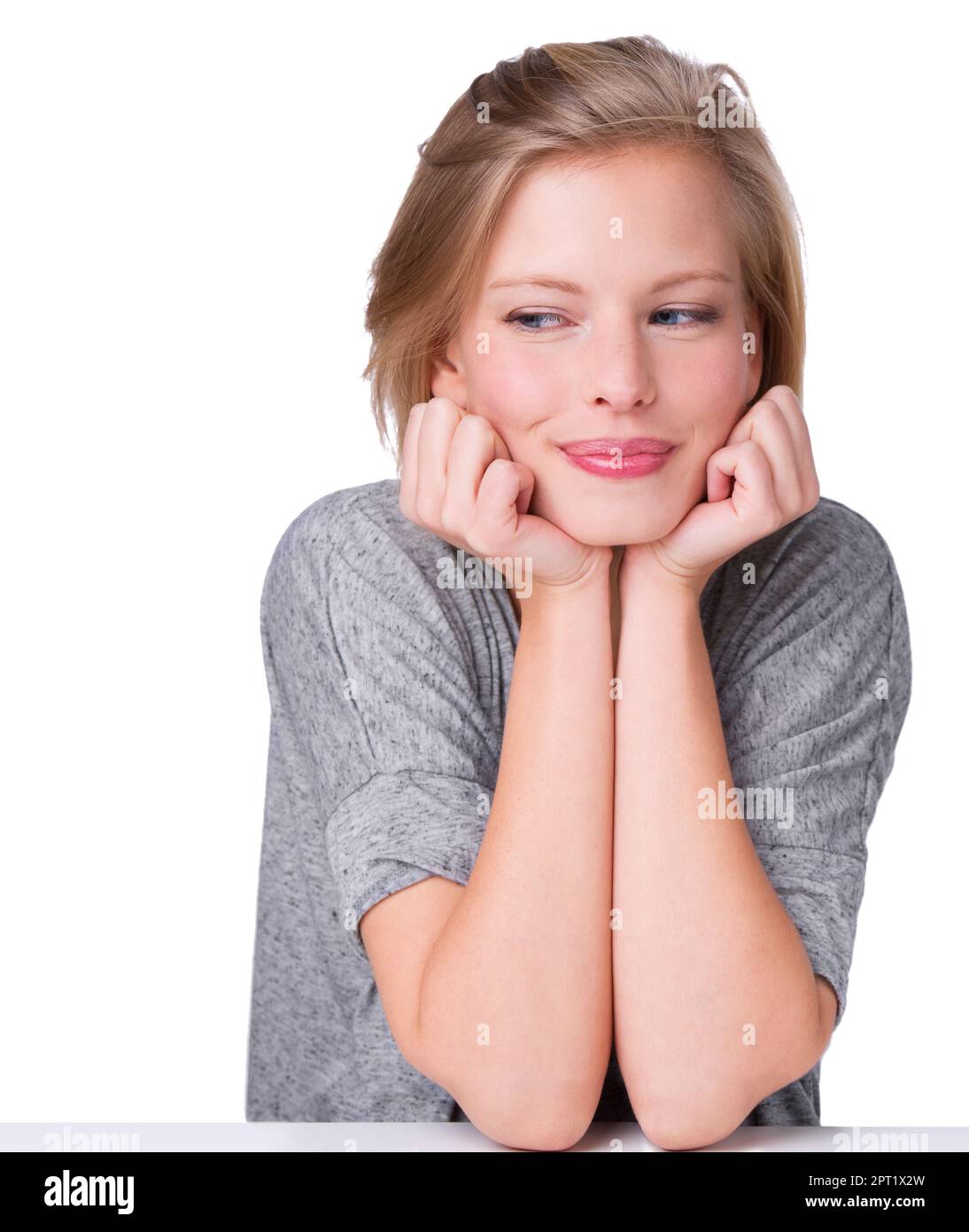 A mischievous smile. An isolated studio shot of a beautiful young woman  leaning on her hands Stock Photo - Alamy