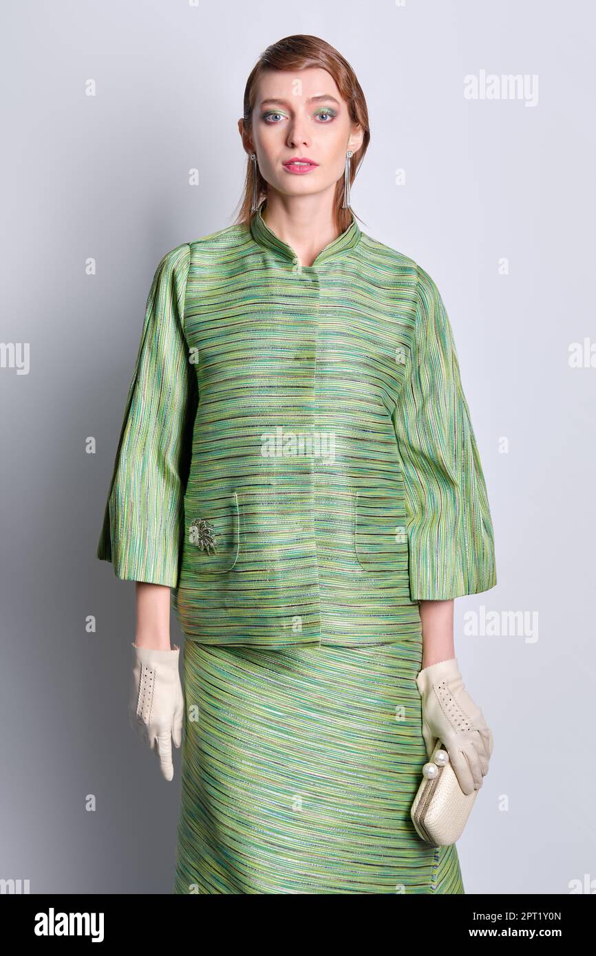 Beautiful young woman in silk green jacket and skirt with old fashioned