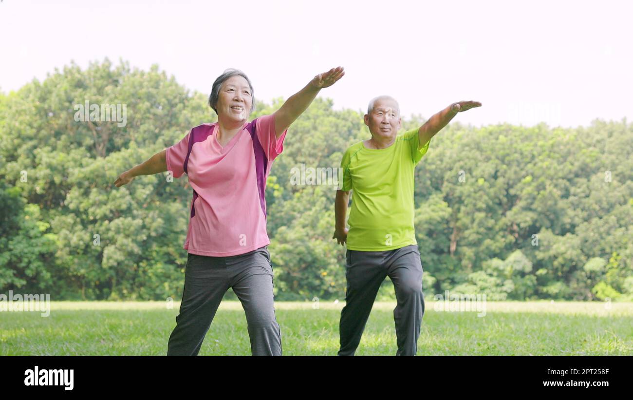 Senior couple exercising and arm stretches in the park Stock Photo - Alamy