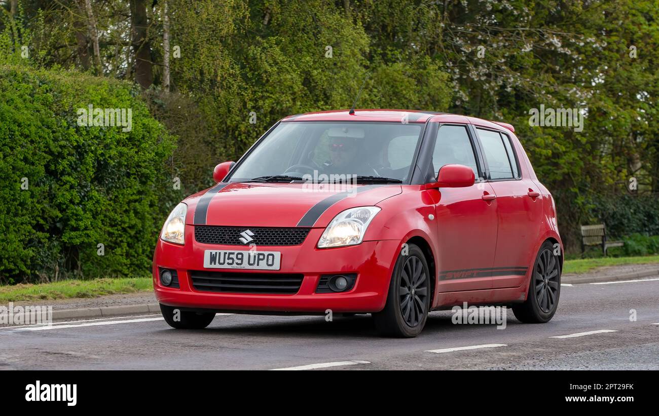 Bicester,Oxon,UK - April 23rd 2023. 2009 red SUZUKI SWIFT   travelling on an English country road Stock Photo