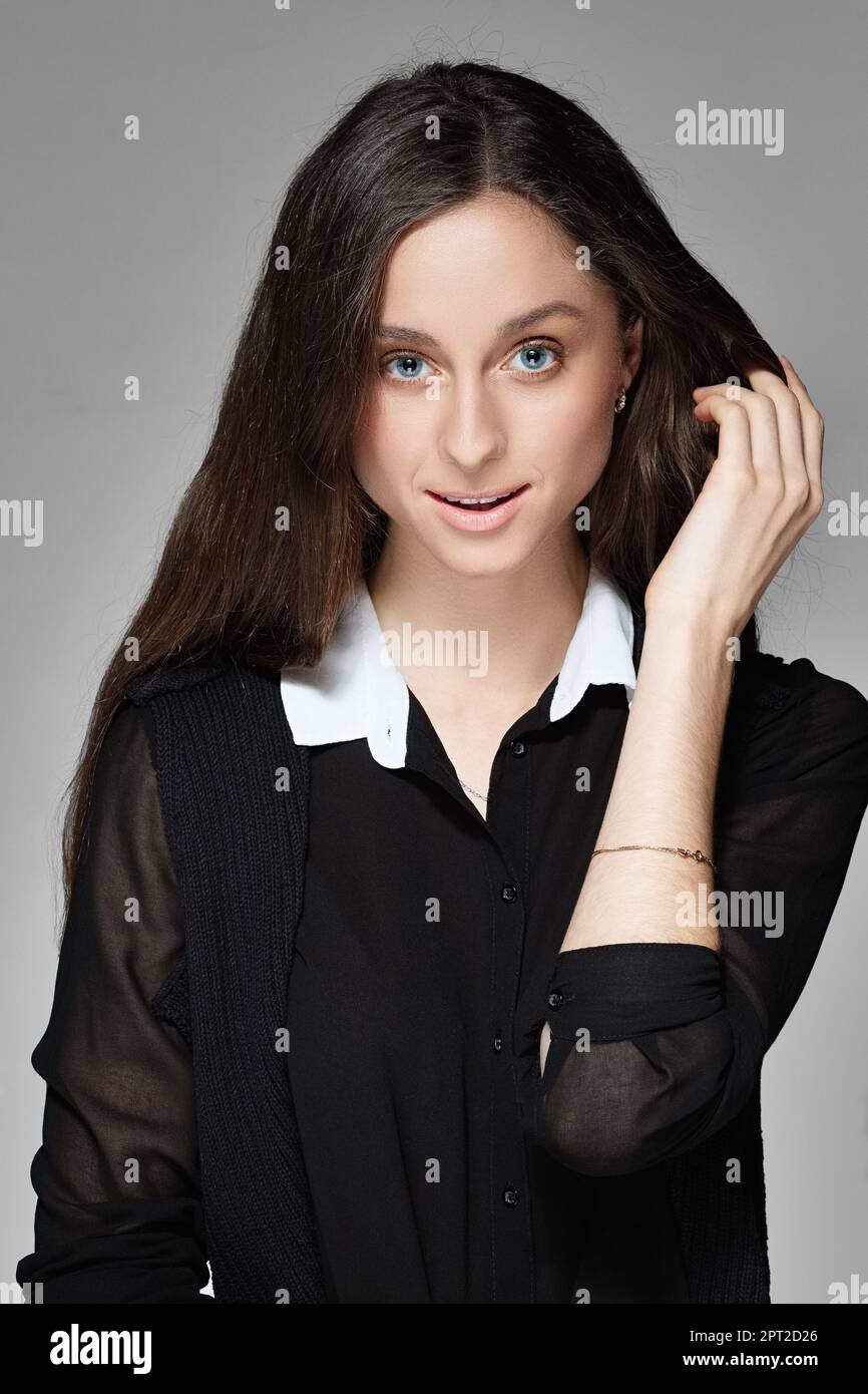 Portrait of a pretty girl with natural make up in black blouse with ...