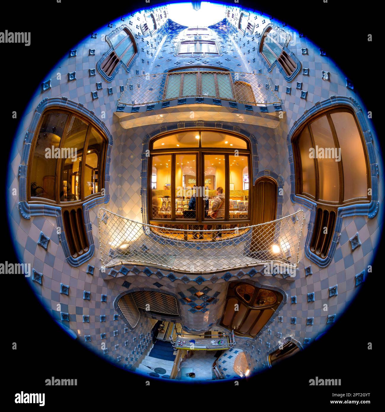 Fisheye view of the interior courtyard of Casa Batlló decorated with a gradient mosaic from blue to white designed by Gaudí. Barcelona Catalonia Spain Stock Photo