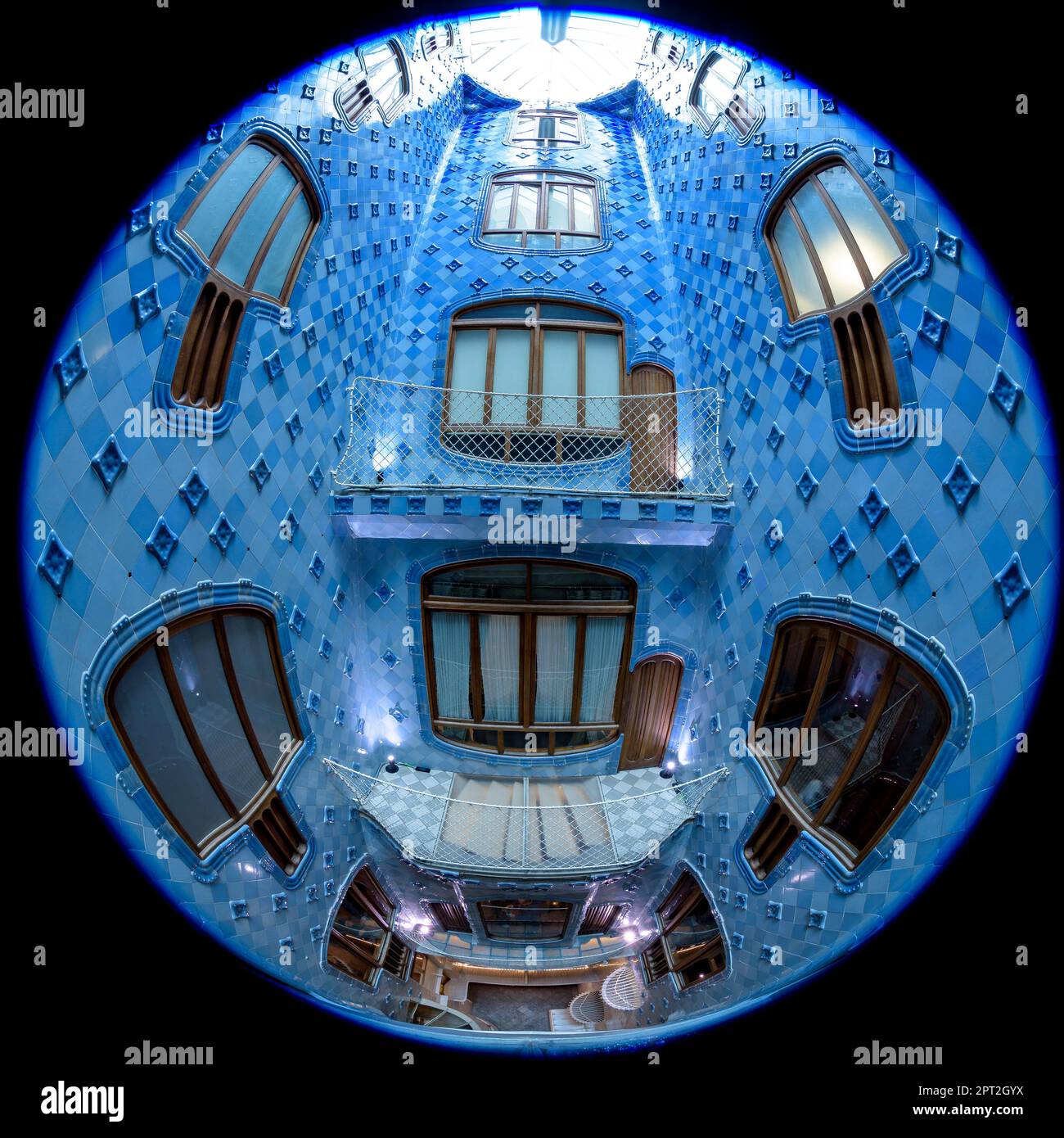 Fisheye view of the interior courtyard of Casa Batlló decorated with a gradient mosaic from blue to white designed by Gaudí. Barcelona Catalonia Spain Stock Photo